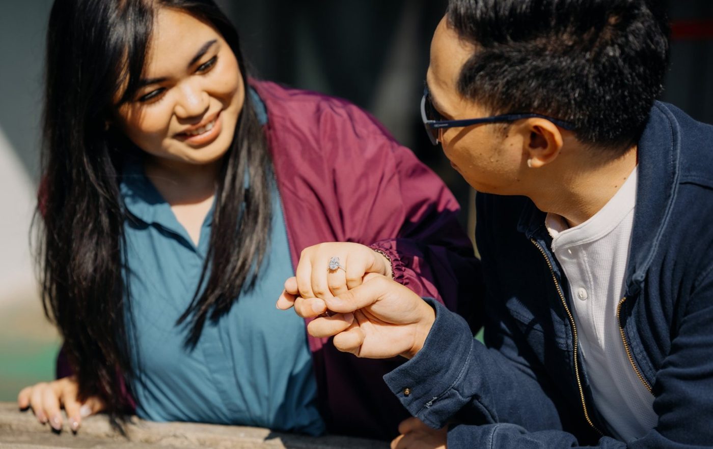 Jay holding Rio's hand, showing her engagement ring